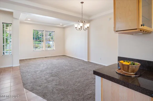 a view of kitchen with granite countertop cabinets and window