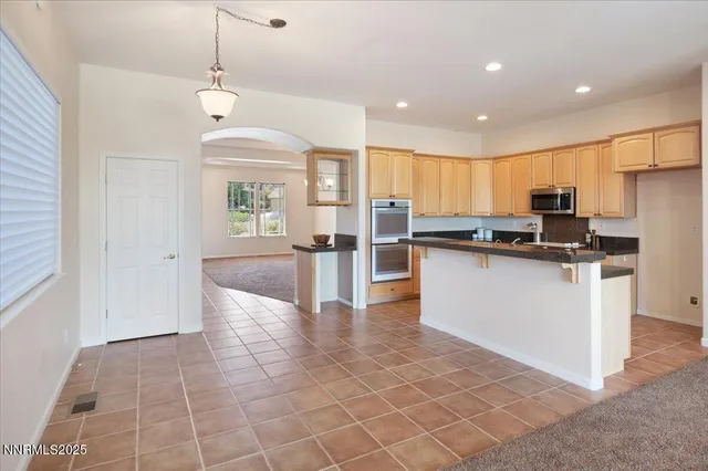 a kitchen with stainless steel appliances granite countertop a refrigerator and a stove top oven