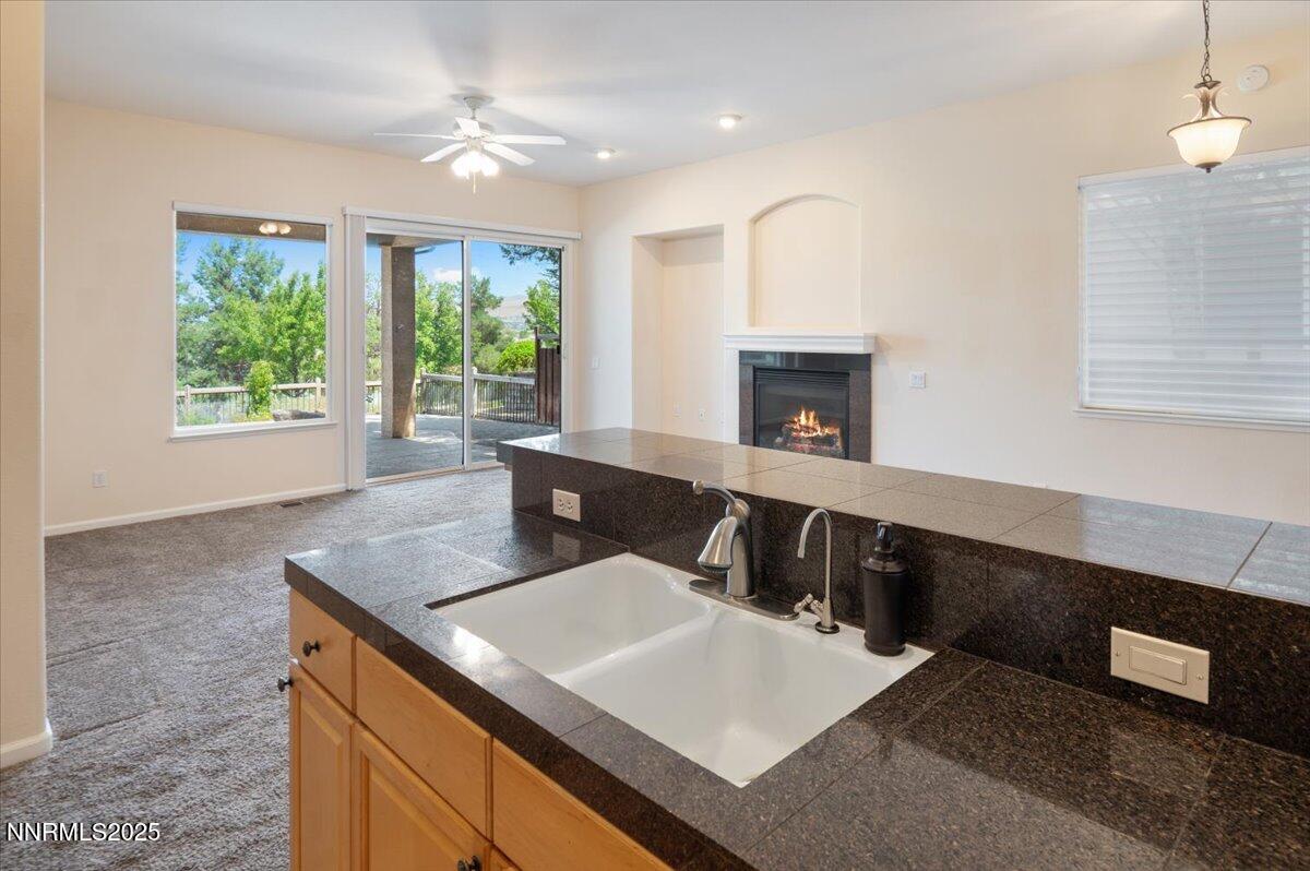 2720 Albazano Drive Sparks, NV 89436 - Photo 17 of 47 a living room with stainless steel appliances granite countertop a sink dishwasher a stove a dining table and chairs with wooden floor