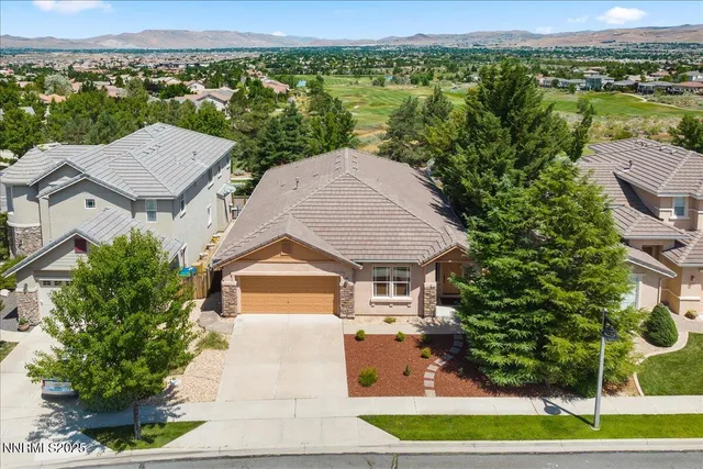 an aerial view of a house with a yard and lake view