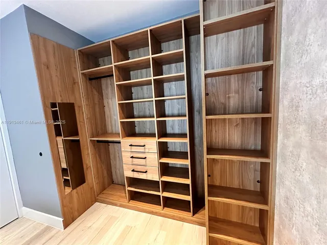 a view of walk in closet with empty racks