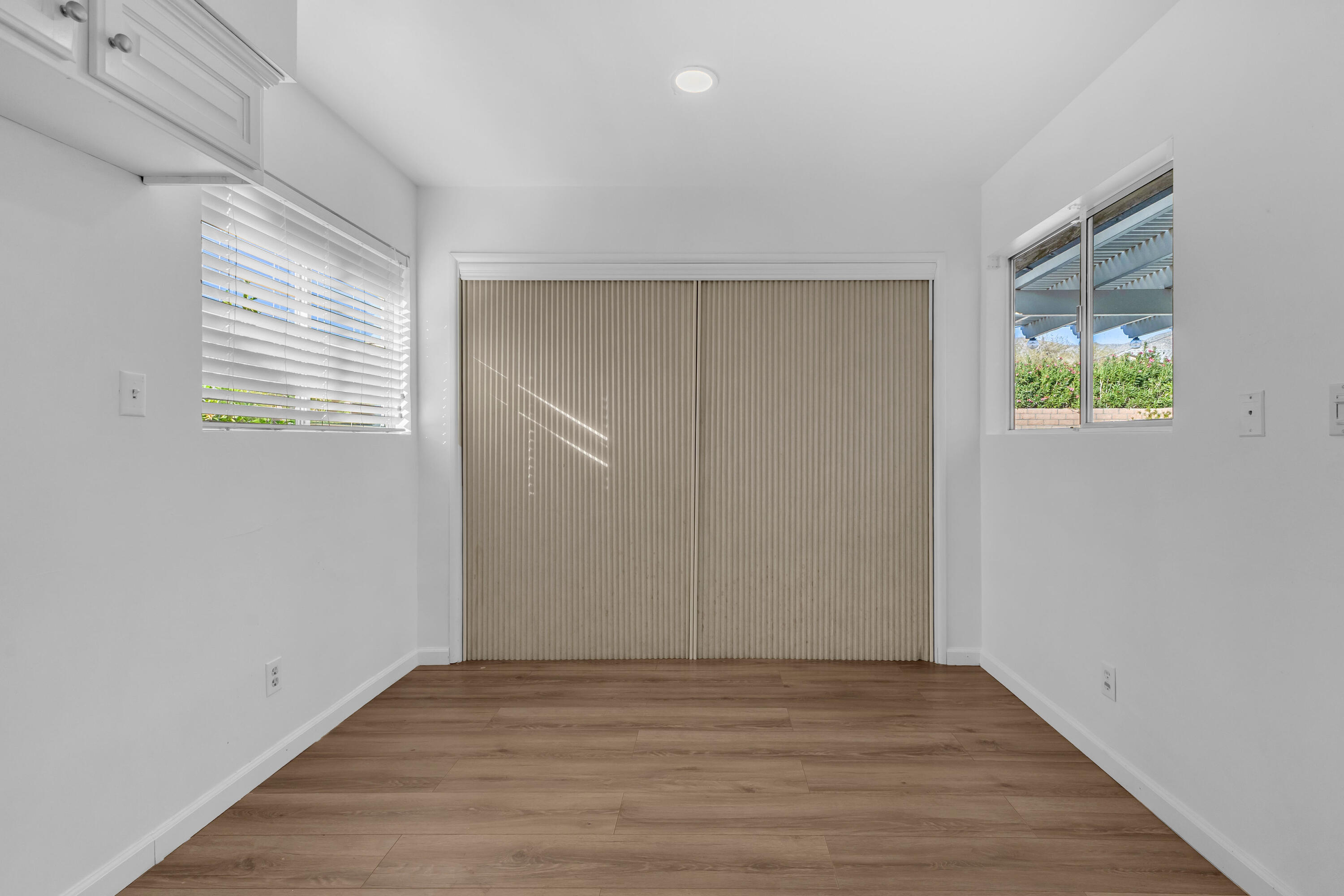 66180 14th Street Desert Hot Springs, CA 92240 - Photo 20 of 42 a view of an empty room with wooden floor and a window