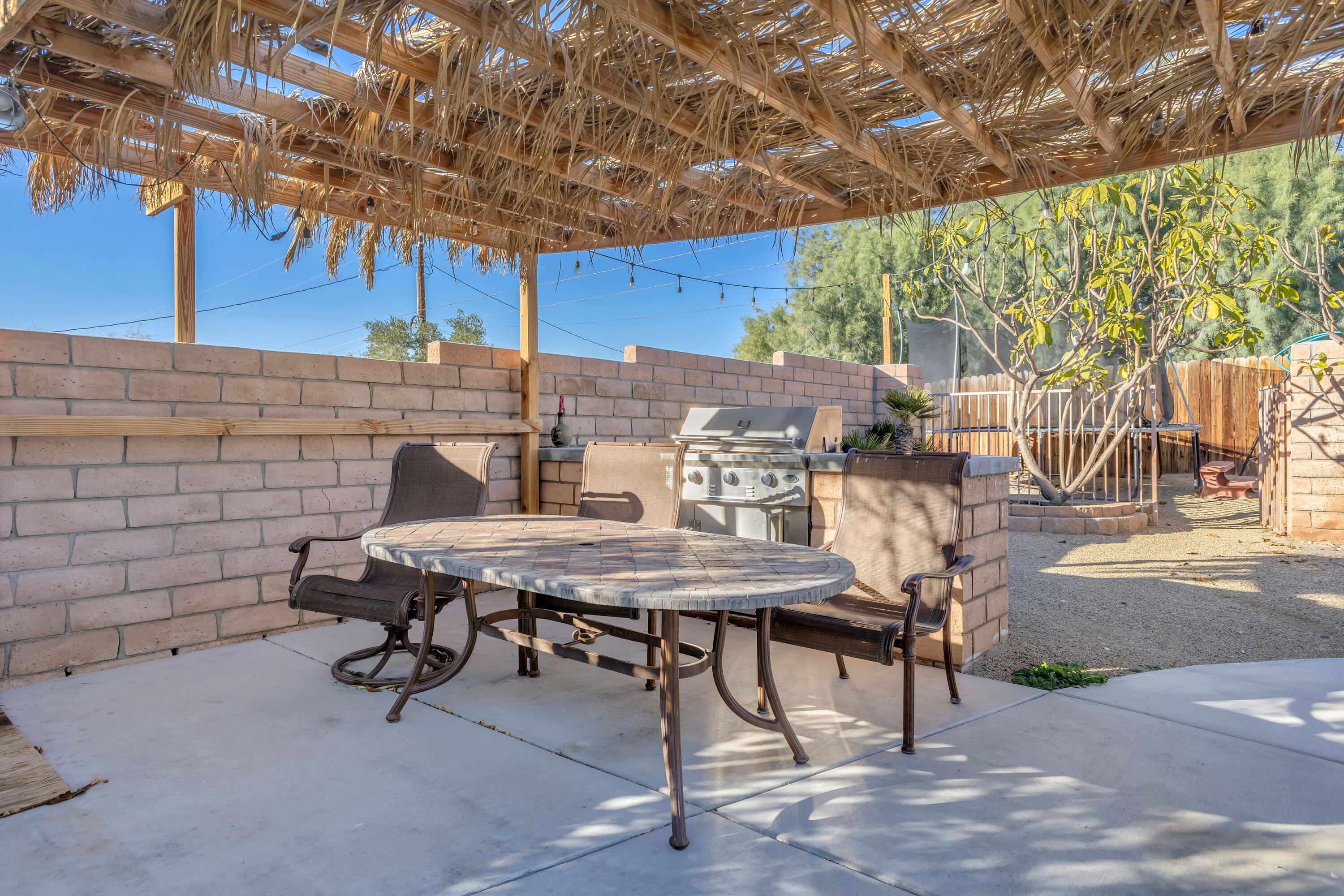 66180 14th Street Desert Hot Springs, CA 92240 - Photo 37 of 42 a view of a patio with table and chairs and potted plants