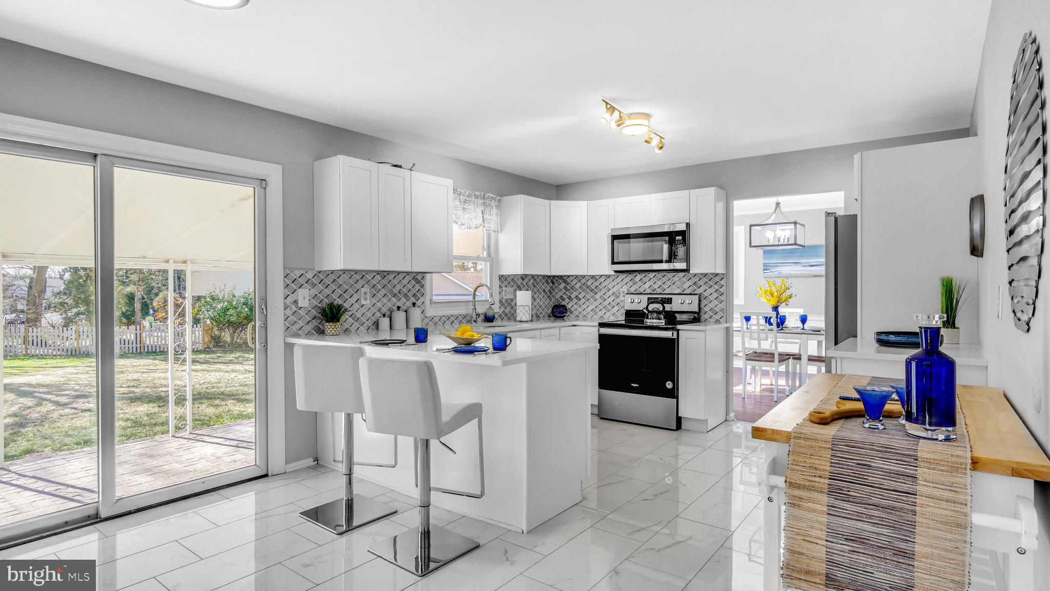 514 Arthur Drive Cherry Hill, NJ 08003 - Photo 13 of 33 a kitchen with a refrigerator a stove a sink a dining table and chairs