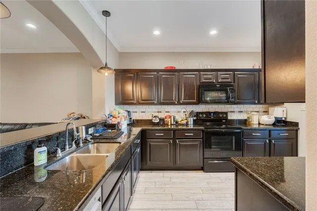 a kitchen with stainless steel appliances granite countertop a sink stove and refrigerator