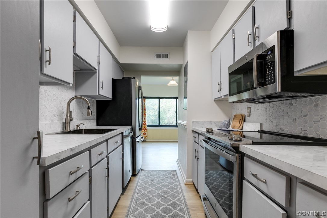 1509 Regency Woods Road, Unit 103 Henrico, VA 23238 - Photo 12 of 31 a kitchen with stainless steel appliances granite countertop a sink stove and microwave
