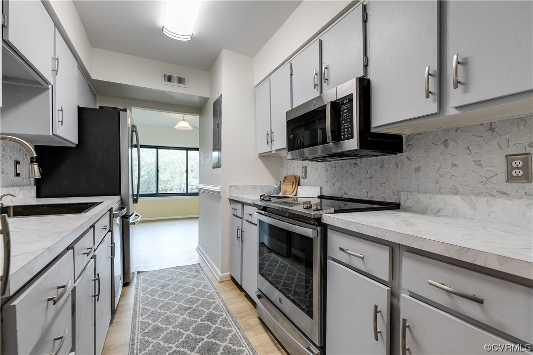 1509 Regency Woods Road, Unit 103 Henrico, VA 23238 - Photo 14 of 31 a kitchen with stainless steel appliances granite countertop a stove a sink and a microwave
