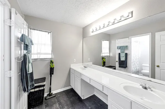 a bathroom with a double vanity sink mirror and bathtub
