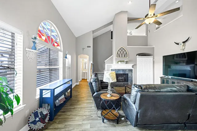a living room with furniture a fireplace and potted plants