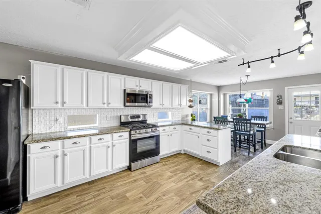 a kitchen with appliances a sink and cabinets