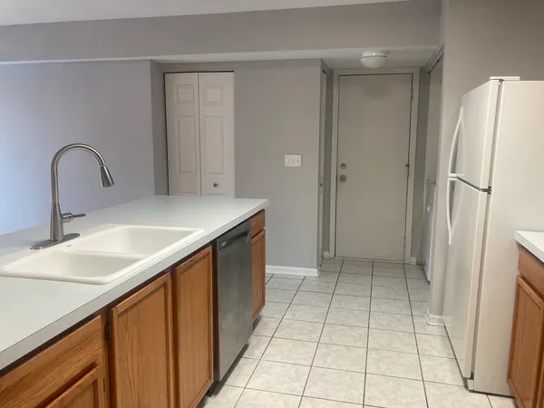 a kitchen with a sink a refrigerator and cabinets