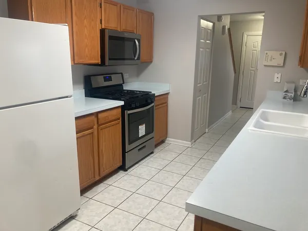 a kitchen with stainless steel appliances a refrigerator sink and microwave