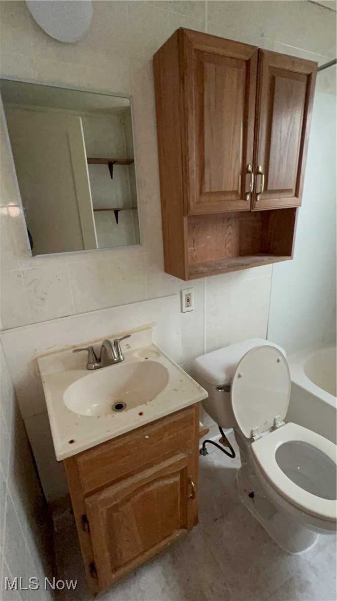 1334 Penhurst Road Cleveland, OH 44110 - Photo 5 of 20 Bathroom featuring toilet, tile walls, backsplash, and vanity