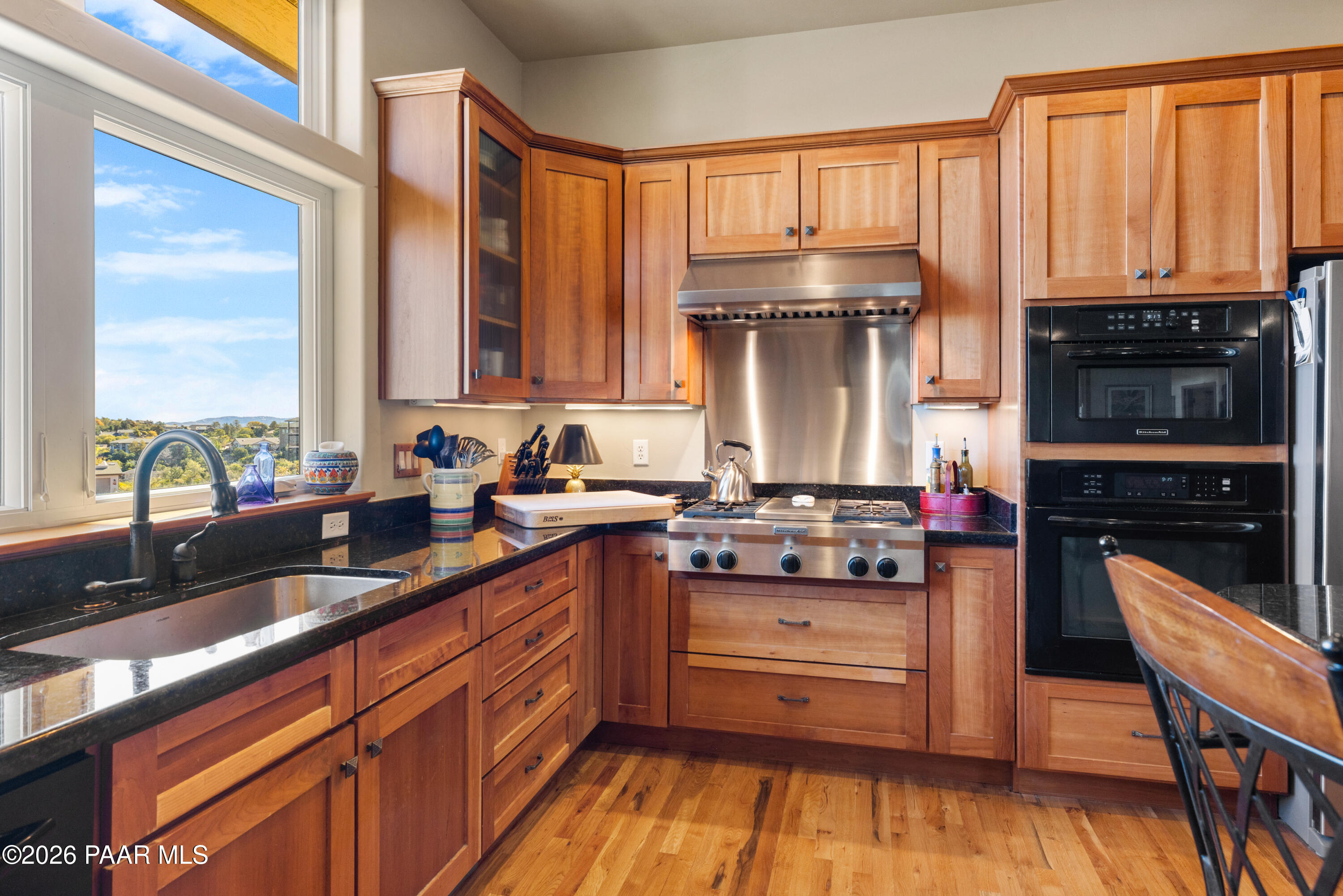 1448 Short Point Lane Prescott, AZ 86305 - Photo 20 of 56 a kitchen with stainless steel appliances granite countertop a stove a sink and a wooden cabinets