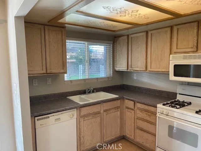 a kitchen with granite countertop white cabinets and white appliances
