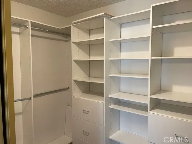 a view of walk in closet with empty racks