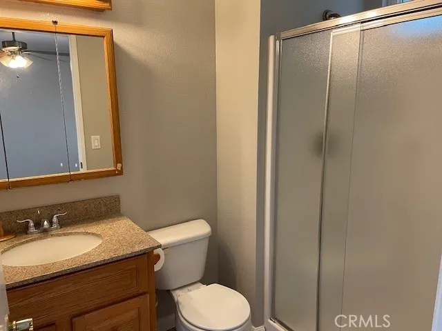 a bathroom with a granite countertop sink toilet and a mirror