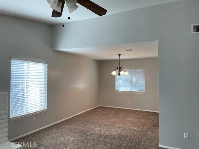 en empty room with windows and ceiling fan