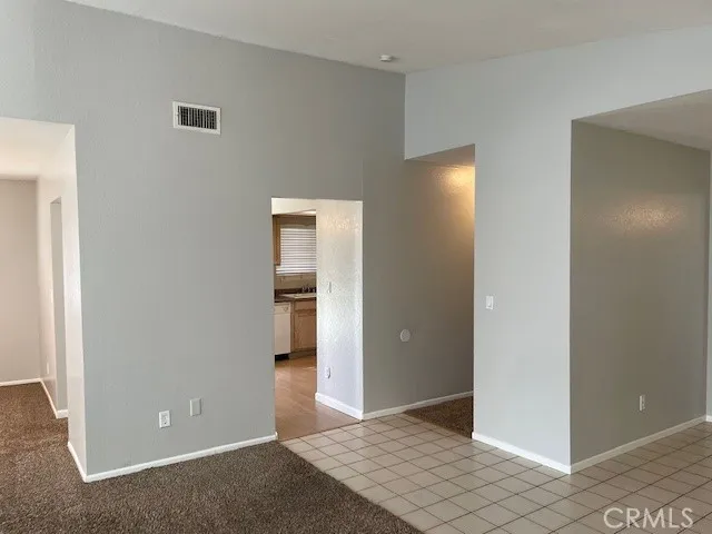 a view of an empty room with closet and a window