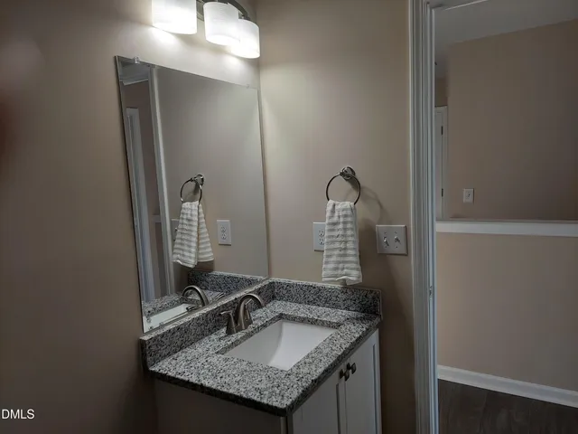 a bathroom with a granite countertop sink and a mirror
