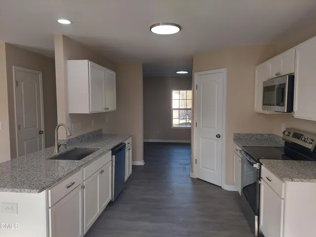 a kitchen with granite countertop a sink and a stove top oven