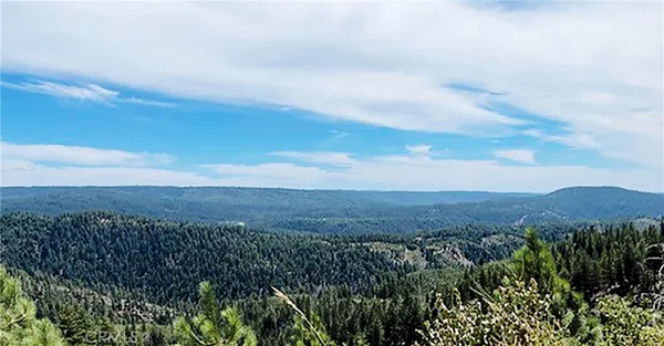 a view of a large mountain with mountains in the background