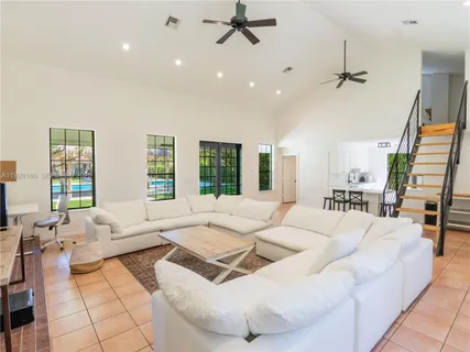 a living room with furniture a flat screen tv and a window