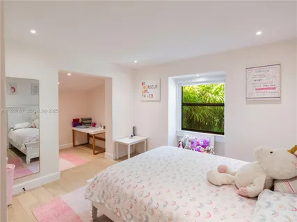 a bedroom with a bed and a large mirror