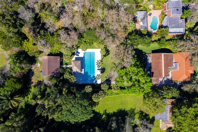an aerial view of residential houses with outdoor space and trees