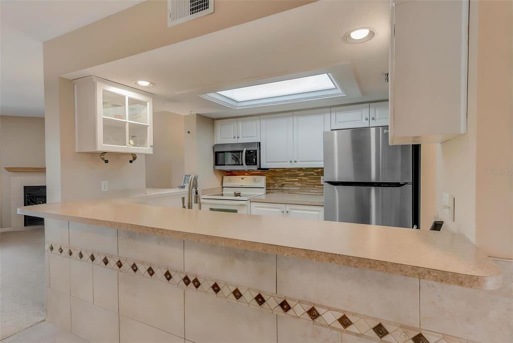 615 Garland Circle Indian Rocks Beach, FL 33785 - Photo 15 of 52 a kitchen with stainless steel appliances granite countertop a refrigerator and a stove top oven