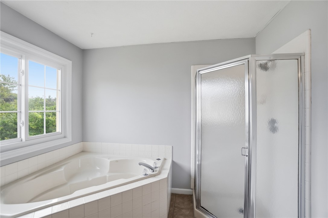 10 Chase Court Springboro, OH 45066 - Photo 38 of 75 This serene bathroom offers a spacious soaking tub and a refreshing glass-enclosed shower.
