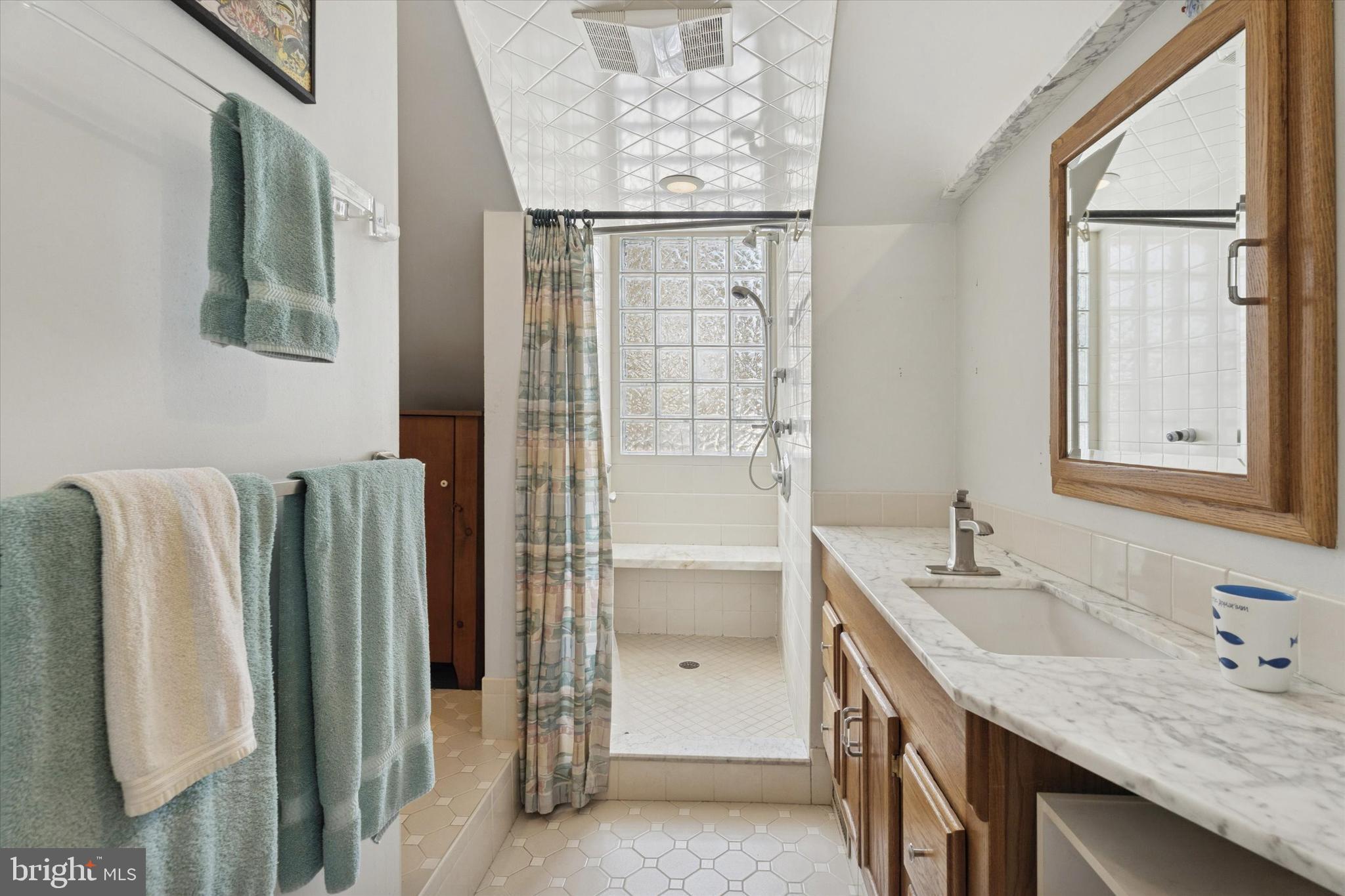 2305 Triebel Road Abington, PA 19001 - Photo 12 of 19 a bathroom with a granite countertop sink a mirror and a bathtub