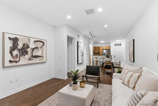 a living room with furniture and a dining table with wooden floor
