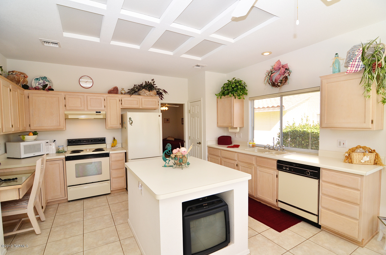 1330 East Crown Ridge Drive Tucson, AZ 85755 - Photo 3 of 22 a kitchen with a sink stove and white cabinets