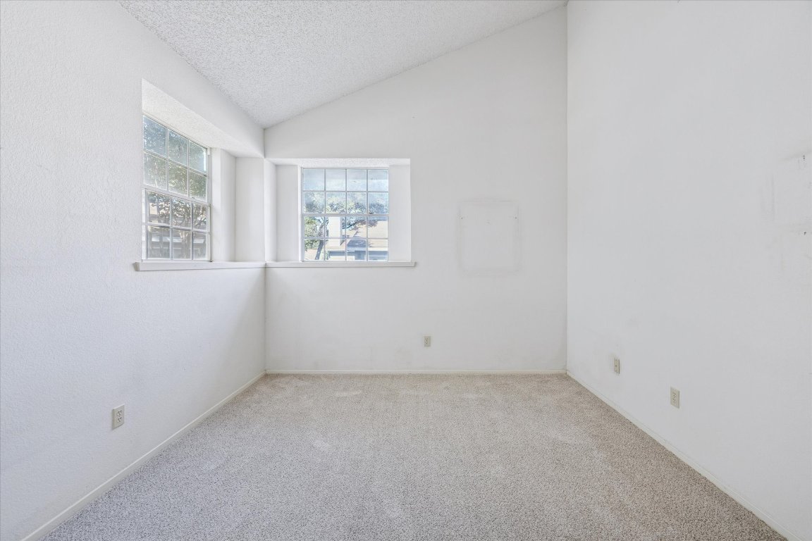 6501 Brush Country Road, Unit 120 Austin, TX 78749 - Photo 21 of 35 Empty room with vaulted ceiling, carpet flooring, and a textured ceiling