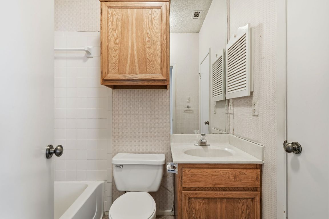6501 Brush Country Road, Unit 120 Austin, TX 78749 - Photo 25 of 35 Bathroom with a textured ceiling, vanity, and shower combination