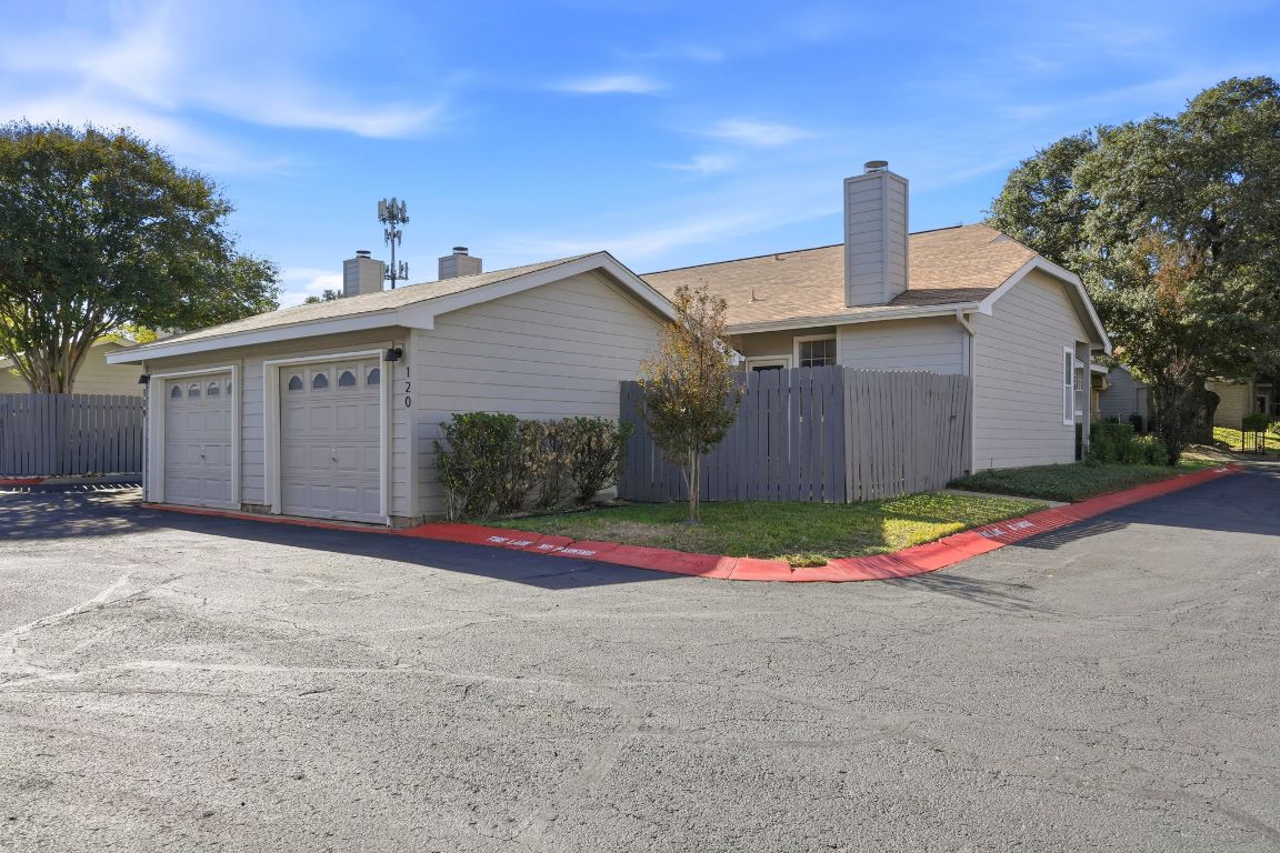 6501 Brush Country Road, Unit 120 Austin, TX 78749 - Photo 35 of 35 View of side of home featuring a chimney, a garage, and an outdoor structure