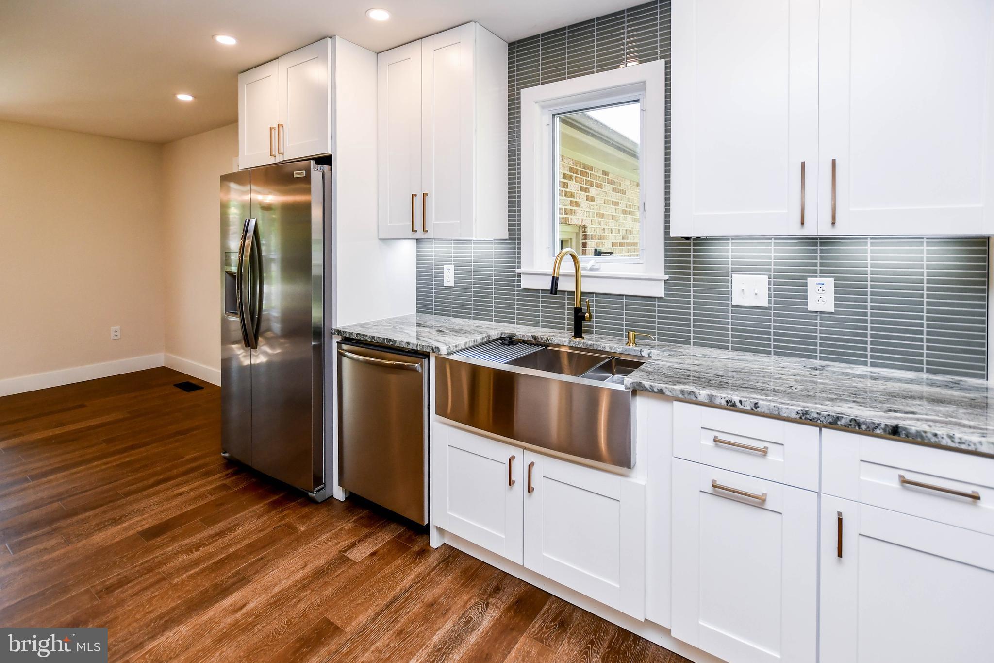 1423 Albert Drive Bowie, MD 20721 - Photo 30 of 86 a kitchen with granite countertop white cabinets and stainless steel appliances