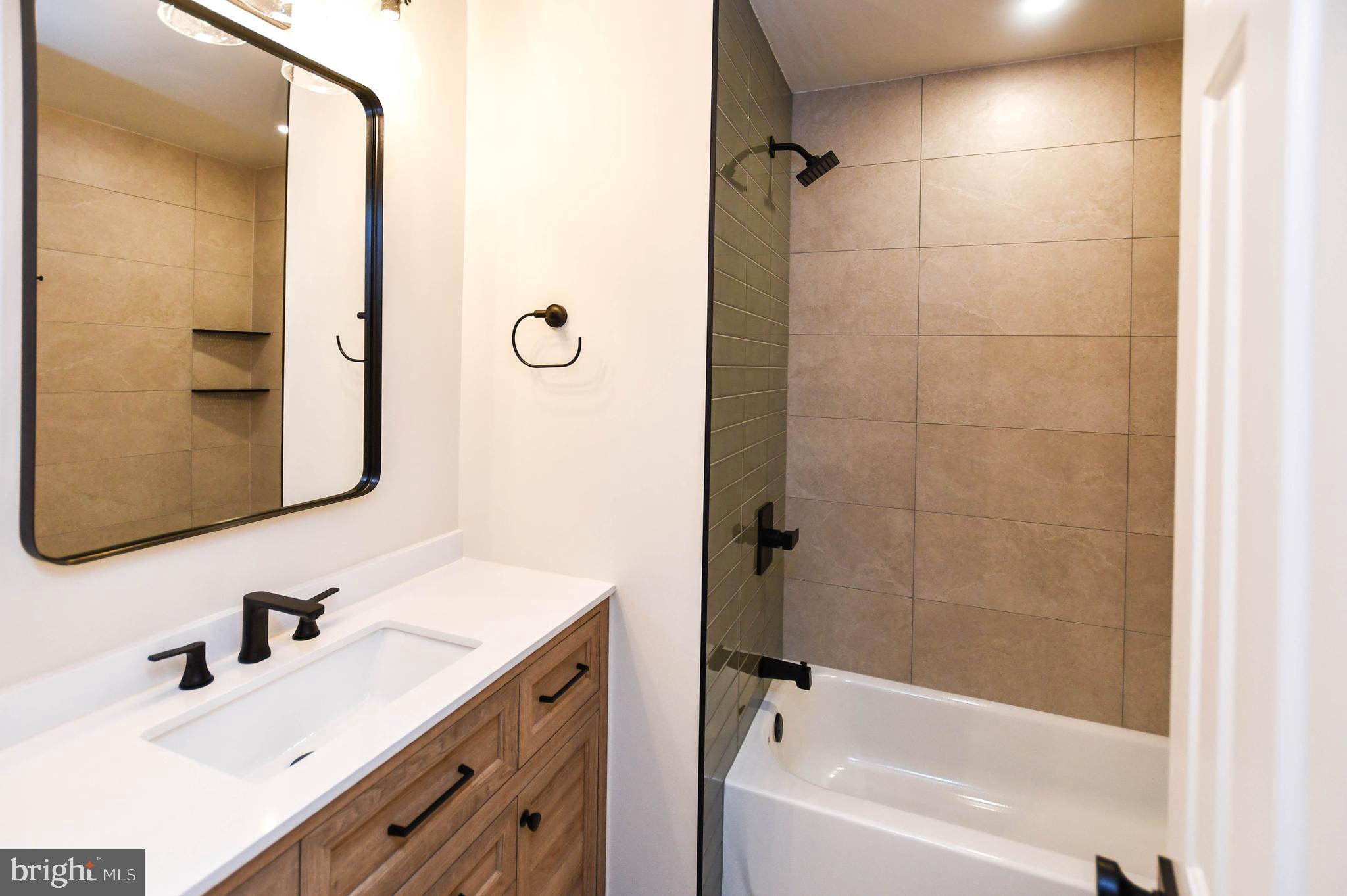 1423 Albert Drive Bowie, MD 20721 - Photo 61 of 86 a bathroom with a bathtub shower sink vanity and mirror