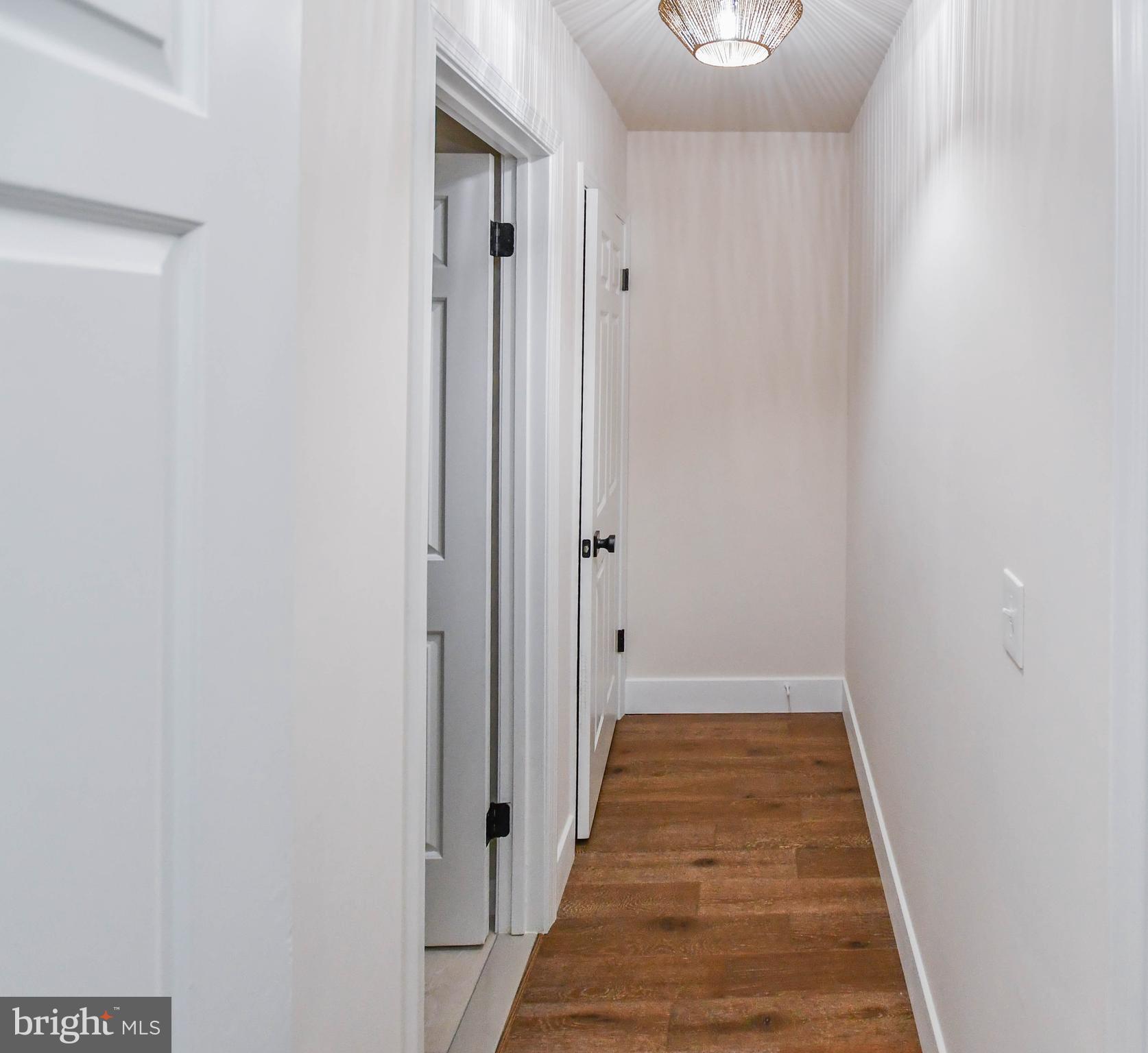 1423 Albert Drive Bowie, MD 20721 - Photo 73 of 86 a view of a hallway with wooden floor and a bathroom