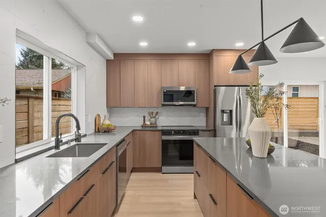 a kitchen with granite countertop a table chairs stove and microwave