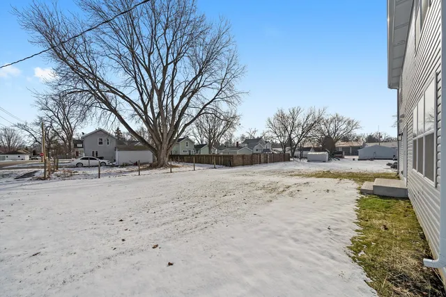 a view of yard covered with snow in front of house
