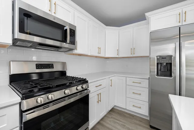 a kitchen with stainless steel appliances a stove a microwave and cabinets