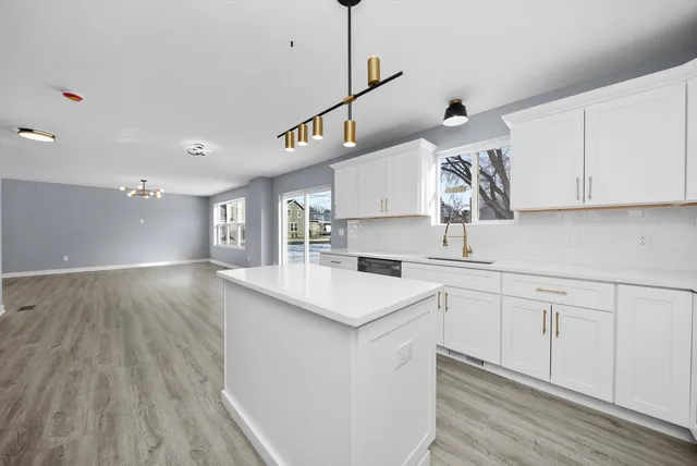 a kitchen with a sink window and cabinets