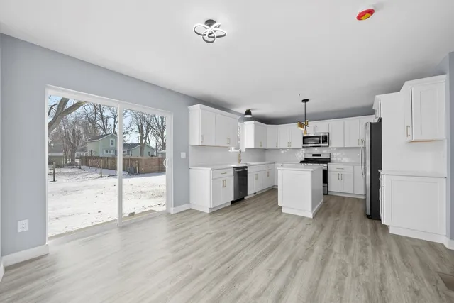 a kitchen with white cabinets and white appliances