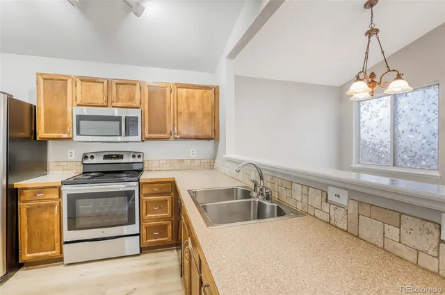 a kitchen that has a sink a stove and a microwave