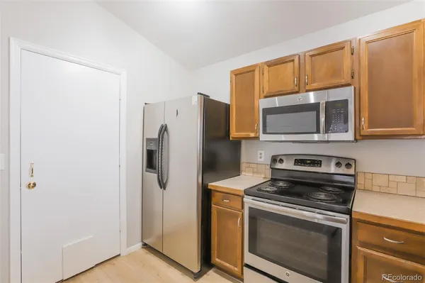 a kitchen with stainless steel appliances a stove microwave and refrigerator