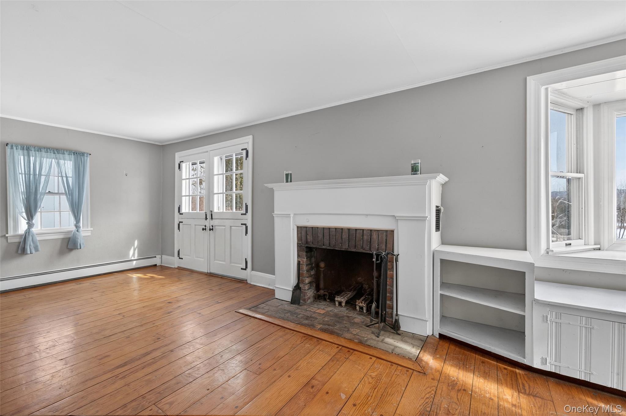 74 Onderdonk Road Warwick, NY 10990 - Photo 15 of 38 an empty room with wooden floor fireplace and windows