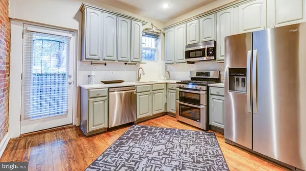 a kitchen with stainless steel appliances granite countertop a stove a sink dishwasher a refrigerator and a microwave