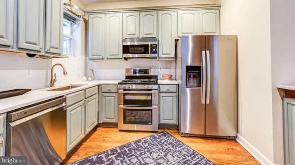 a kitchen with stainless steel appliances granite countertop a refrigerator stove and sink
